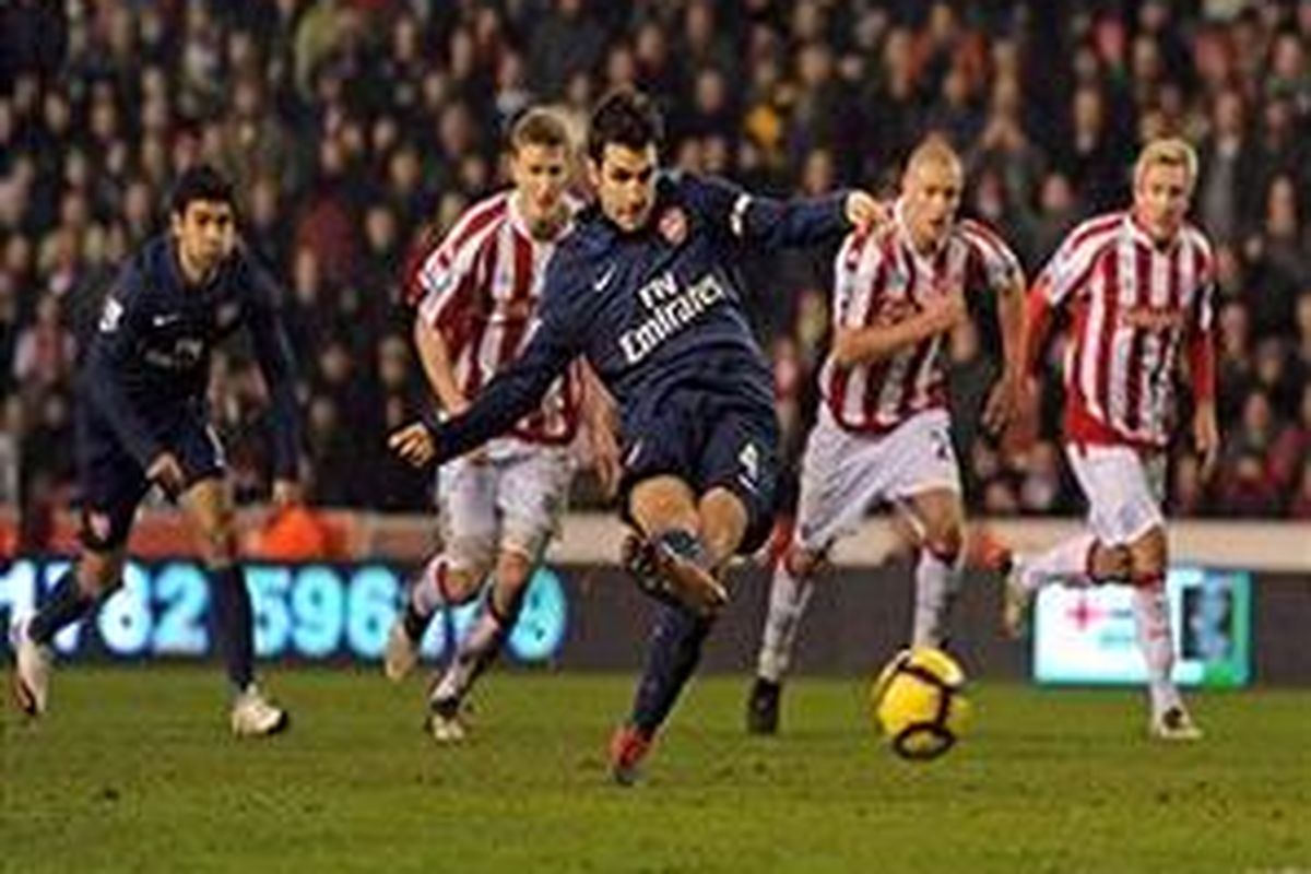 Kapten Arsenal, Cesc Fabregas, melakukan tendangan penalti yang mengantar timnya menang 3-1 atas Stoke City.