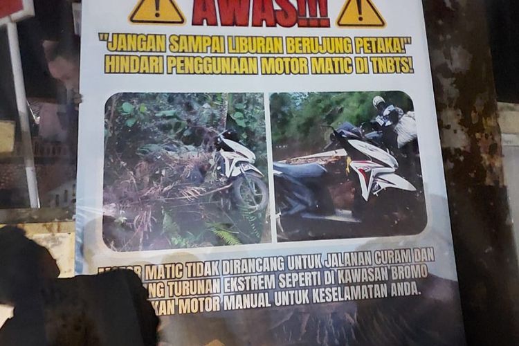 Petugas memasang banner peringatan agar wisatawan Bromo tidak menggunakan motor matic. 