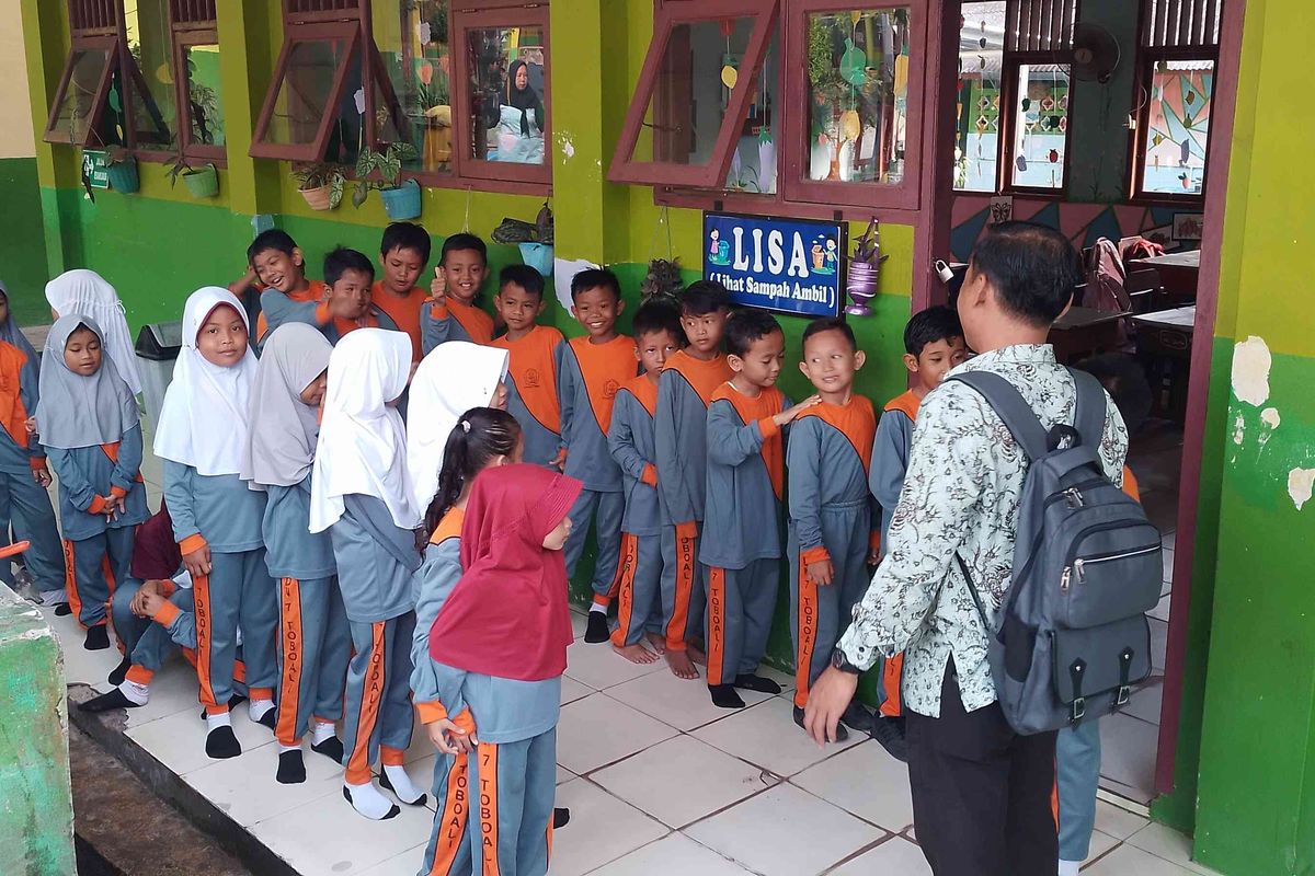 Siswa sekolah berbaris sebelum masuk ke ruang kelas.