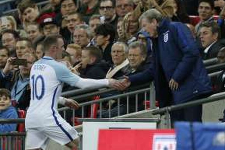 Striker Inggris, Wayne Rooney (kiri), berjabat tangan dengan manajer Inggris Roy Hodgson setelah dia ditarik keluar dalam laga persahabatan melawan Portugal di Stadion Wembley, Kamis (2/6/2016).