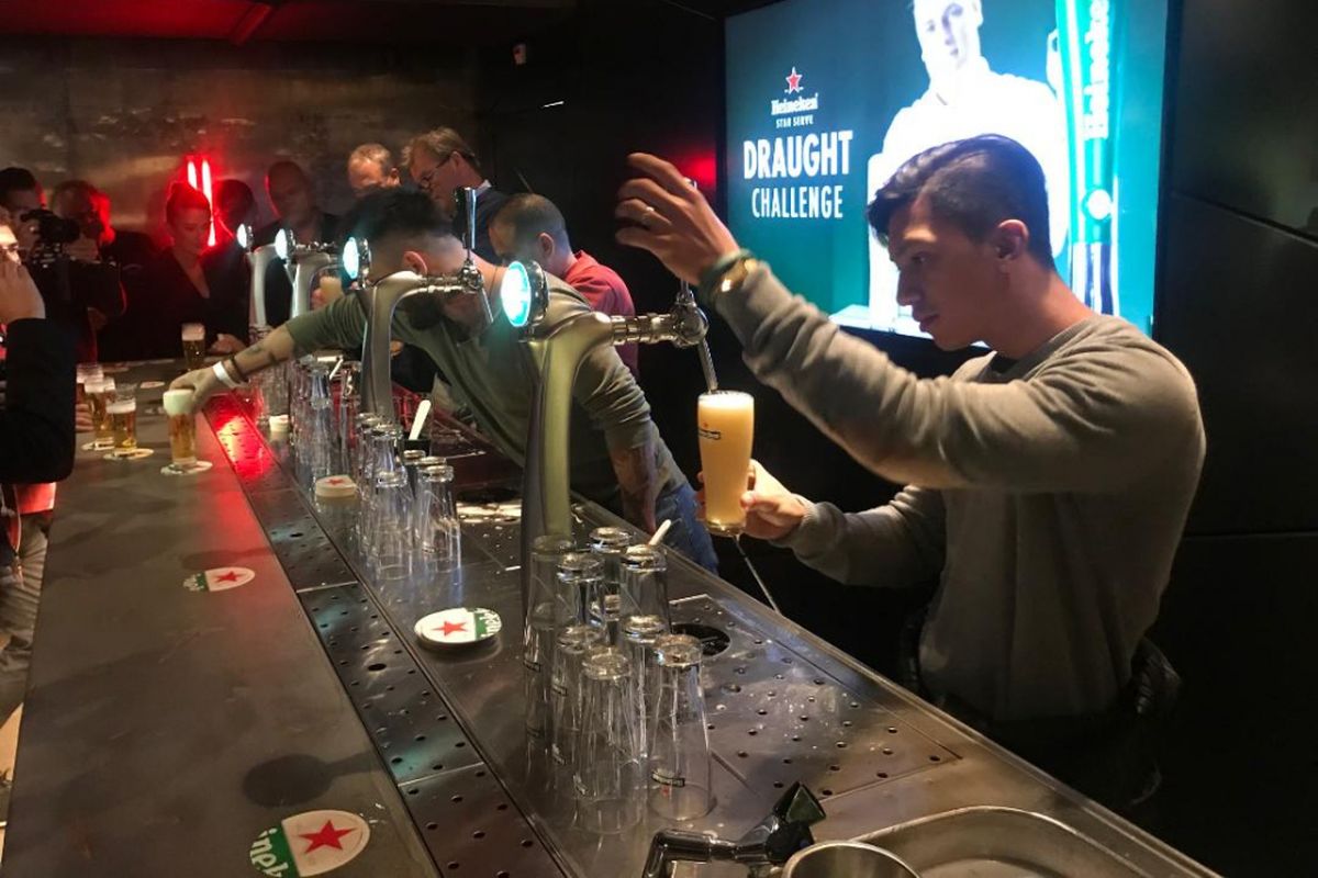 Bartender sedang menuang bir dari mesin draught.
