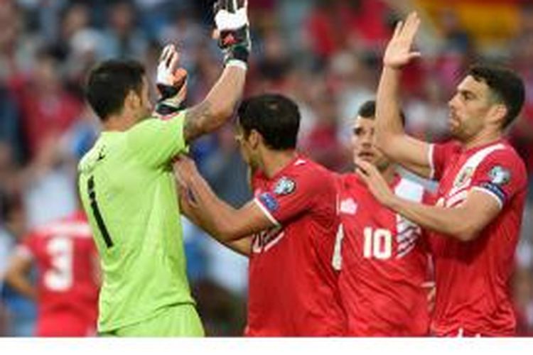 Kiper Gibraltar Jordan Perez (kiri) mendapat sambutan dari rekan-rekannya setelah dia berhasil menahan tendangan penalti Bastian Schweinsteiger pada laga penyisihan Grup D Kualifikasi Piala Eropa 2016 di Stadion Algarve, Sabtu (13/6/2015).