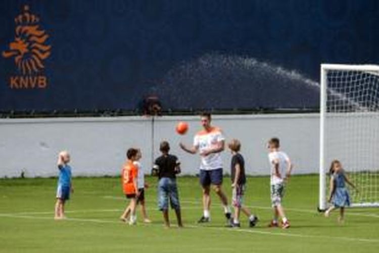 Striker Belanda, Robin van Persie, bermain bersama anaknya, Shaqueel (baju oranye), Dina (paling kanan), serta anak-anak dari rekan setimnya saat sesi latihan tim di Rio de Janeiro, Sabtu (14/6/2014).