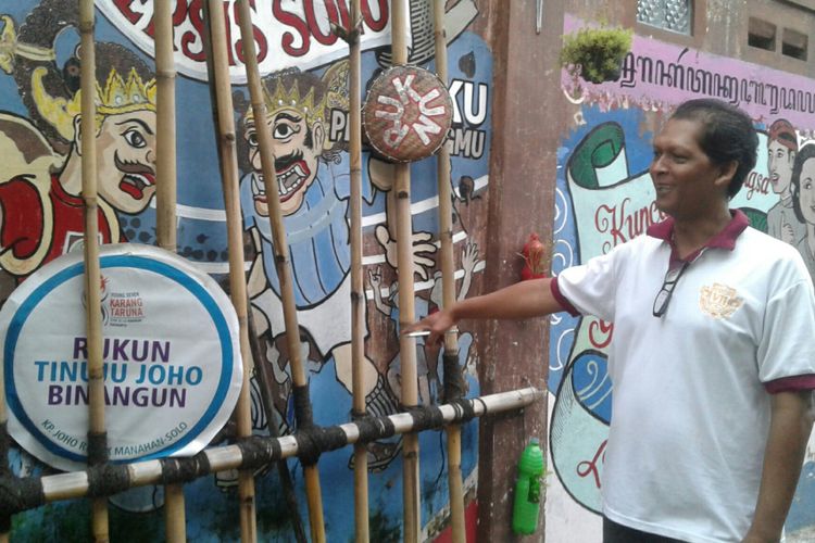 Penggiat kampung Joho, Yunus Ariseno menunjuk mural suporter Persis Solo di balik anyaman bambu di gang masuk kampung Joho di Solo, Jawa Tengah.