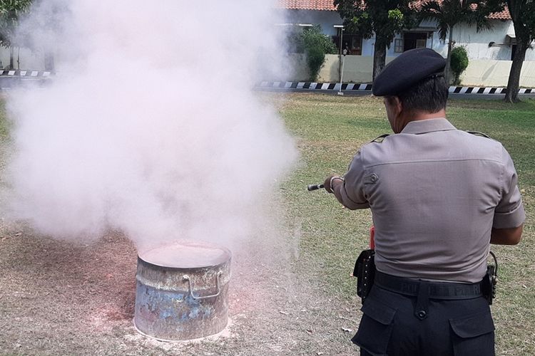 Salah seorang anggota Sat Sabhara Polres Pemalang Jawa Tengah mencoba memadamkan api dengan Apar.