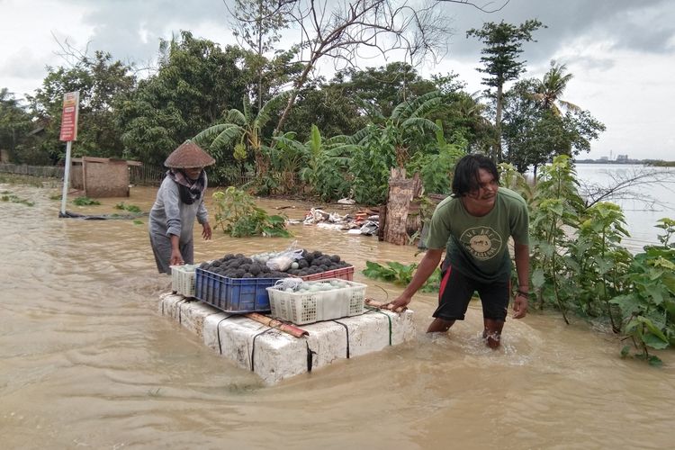 Warga Desa Karangligar,  Kecamatan Telukjambe Barat, Kabupaten Karawang, mengamankan telur asin produksinya agar tidak terendam banjir, Rabu (26/2/2020).