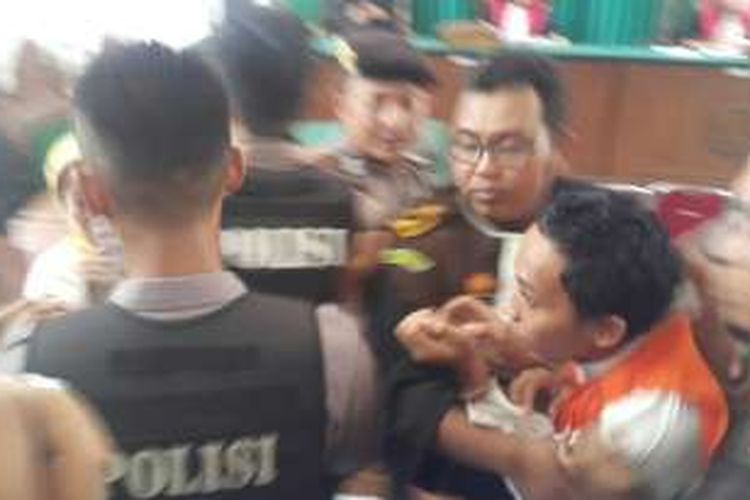 Foto : Terdakwa Heri Purwanto, pembunuh mantan istrinya, Iin Triana Dewi dikawal jaksa dan aparat kepolisian saat hendak keluar dari ruang sidang Pengadilan Negeri Madiun, Rabu (28/12/2016).