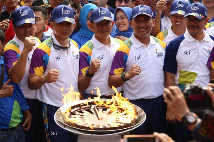 Walikota Jakarta Selatan Marullah Matali (pertama kanan) berpose di depan Obor Asian Games saat Torch Relay Asian Games 2018 di Kebun Binatang Ragunan, Jakarta Selatan, Rabu (15/08/2018). Api Asian Games akan diarak mengelilingi 5 Kota dan 1 Kabupaten di Provinsi DKI Jakarta