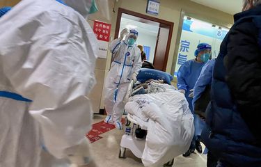 Petugas medis membawa seorang pasien Covid-19 di Rumah Sakit Chongqing No 5 di China, 23 Desember 2022.