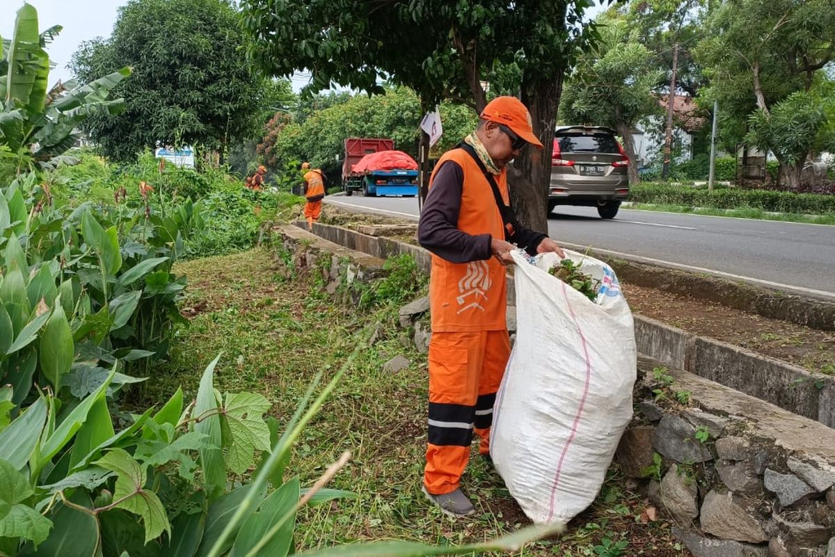 Petugas PPSU dari Kelurahan Pondok Kopi yang sedang membersihkan gulma dan mengumpulkan sampah di samping Stasiun Cakung, Jakarta Timur menuju ke wilayah Kota Bekasi.
