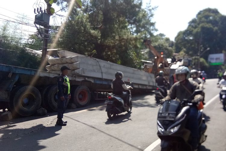 Sejumlah petugas sedang melakukan evakuasi terhadap muatan tiang pancang yang jatuh di Jalan Raya Puncak, Rabu (6/11/2019).