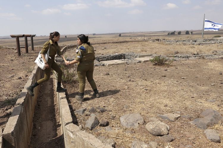 Tentara Israel berkumpul di atas bukit Tal Saki dekat Moshav of Eliad di Dataran Tinggi Golan yang dianeksasi Israel pada 19 September 2022. Pada Minggu (12/3/2023), media pemerintah Suriah, SANA, melaporkan serangan udara Israel yang menargetkan lokasi di Suriah tengah dan barat pada Minggu pagi melukai tiga tentara.