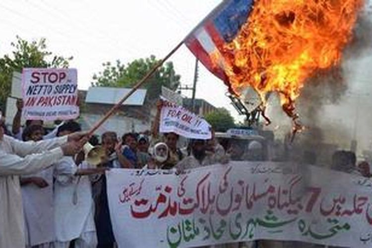Warga Pakistan membakar bendera Amerika Serikat dalam aksi memprotes serangan drone yang dianggap melanggar kedaulatan Pakistan.