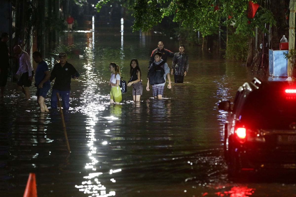 Warga melintasi banjir yang mengenang kawasan Kemang, Jakarta Selatan, Kamis (6/10/2022) malam. Hujan deras yang mengguyur wilayah Jakarta siang menyebabkan Jalan Kemang Raya, Jakarta Selatan, terendam banjir.