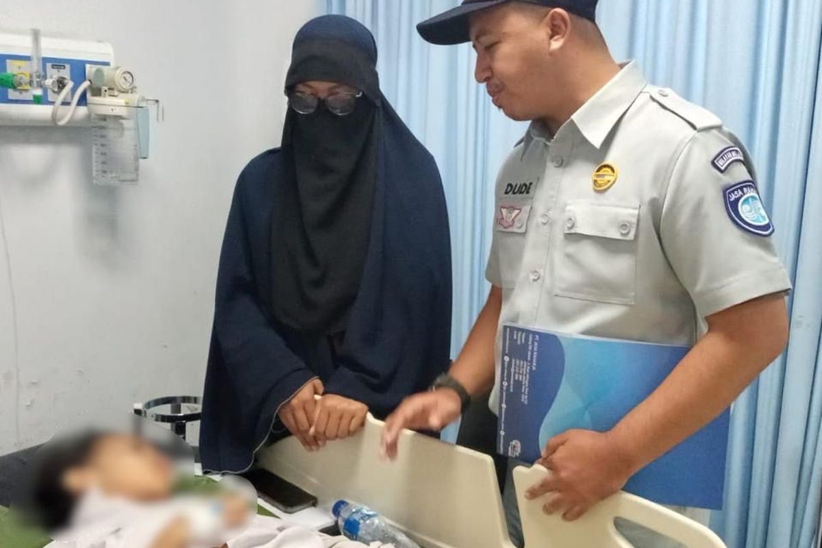 Petugas Jasa Raharja berbincang dengan siswa SDN Kalibaru 01 Pagi yang menjadi korban kecelakaan.