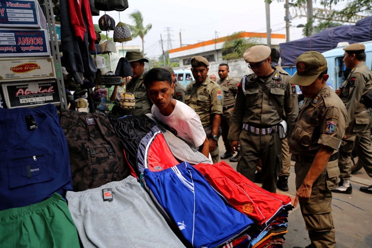 Petugas Satpol PP melakukan penertiban pedagang kaki lima (PKL) yang berjualan di Kawasan Pasar Tanah Abang, Jakarta, Rabu (17/5/2017). Penertiban dilakukan setiap hari menyusul mulai banyaknya PKL yang berjualan di trotoar dan jalan kawasan Pasar Tanah Abang.