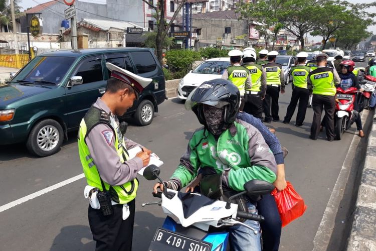 Seorang pengendara sepeda motor ditilang polisi saat terjaring Operasi Zebra di Jalan Margonda Depok, Kamis (1/11/2018). 