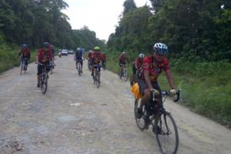 Peserta Jelajah Sepeda Papua melewati jalan rusak dalam perjalanan menuju Bonggo dari Sarmi, Papua, Rabu (3/5/2015).
