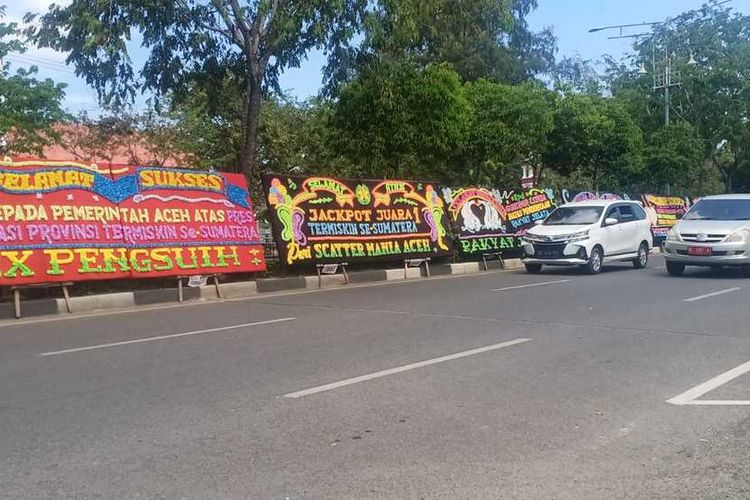 Sejumlah papan bunga ucapan selamat kepada Pemerintah Provinsi Aceh, sebagai bentuk sindiran atas kegagalan Pemerintah Aceh dalam menurunkan angka kemiskinan, tampak berjejer di depan kantor Gubernur Aceh di sepanjang Jalan Teuku Nyak Arief, Rabu (17/2/2021). Aceh tercatat sebagai provinsi dengan angka kemiskinan tertinggi di Sumatera dalam beberapa tahun terakhir.