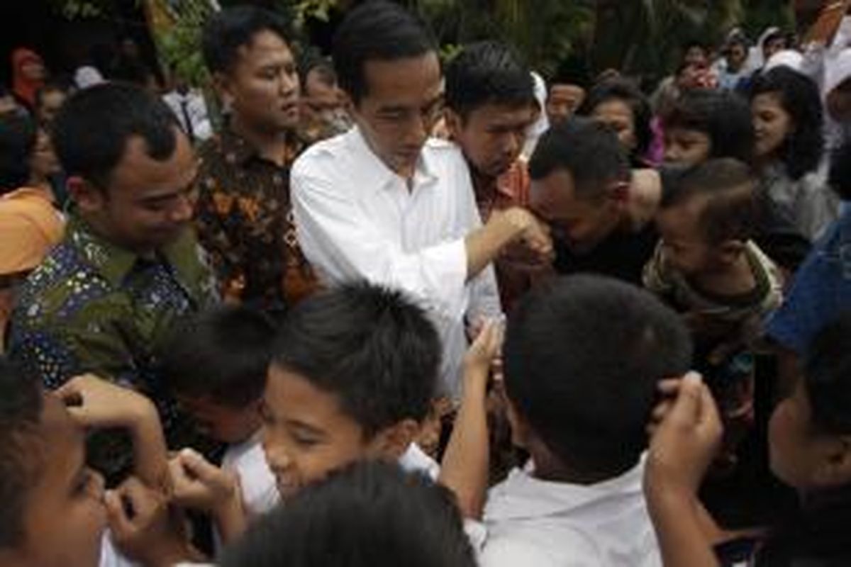 Calon presiden yang juga Gubernur DKI Jakarta, Joko Widodo atau Jokowi, saat mengunjungi SD Negeri 05, Kampung Gedong, Pasar Rebo, Jakarta Timur, Selasa (18/3/2014). Dalam kunjungannya, Jokowi bertanya kepada para murid mengenai Kartu Jakarta Pintar yang telah dibagikan oleh Pemprov DKI Jakarta. KOMPAS IMAGES/RODERICK ADRIAN MOZES