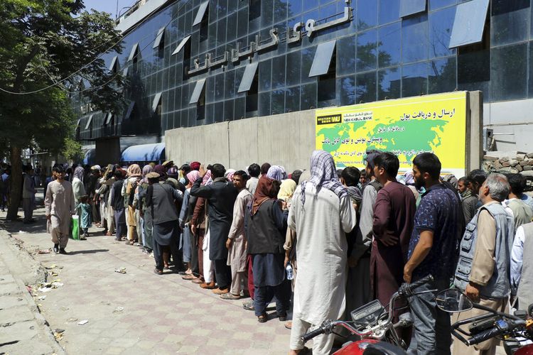 Warga Afghanistan menunggu di depan Kabul Bank, di Kabul, Afghanistan, Rabu, 25 Agustus 2021.