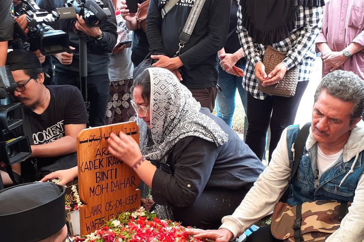 Dewi Irawan didampingi Adhi Bambang Irawan di pusara ibunya Ade Irawan di TPU Tanah Kusir, Kebayoran Lama, Jakarta Selatan, Sabtu (18/1/2020).