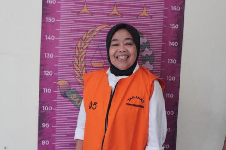 Kades Cikujang, Sukabumi, tersenyum lebar saat difoto memakai rompi tahanan pidsus Kejari Kab Sukabumi, usai ditetapkan tersangka kasus korupsi dana desa, Senin (28/7/2025). 

