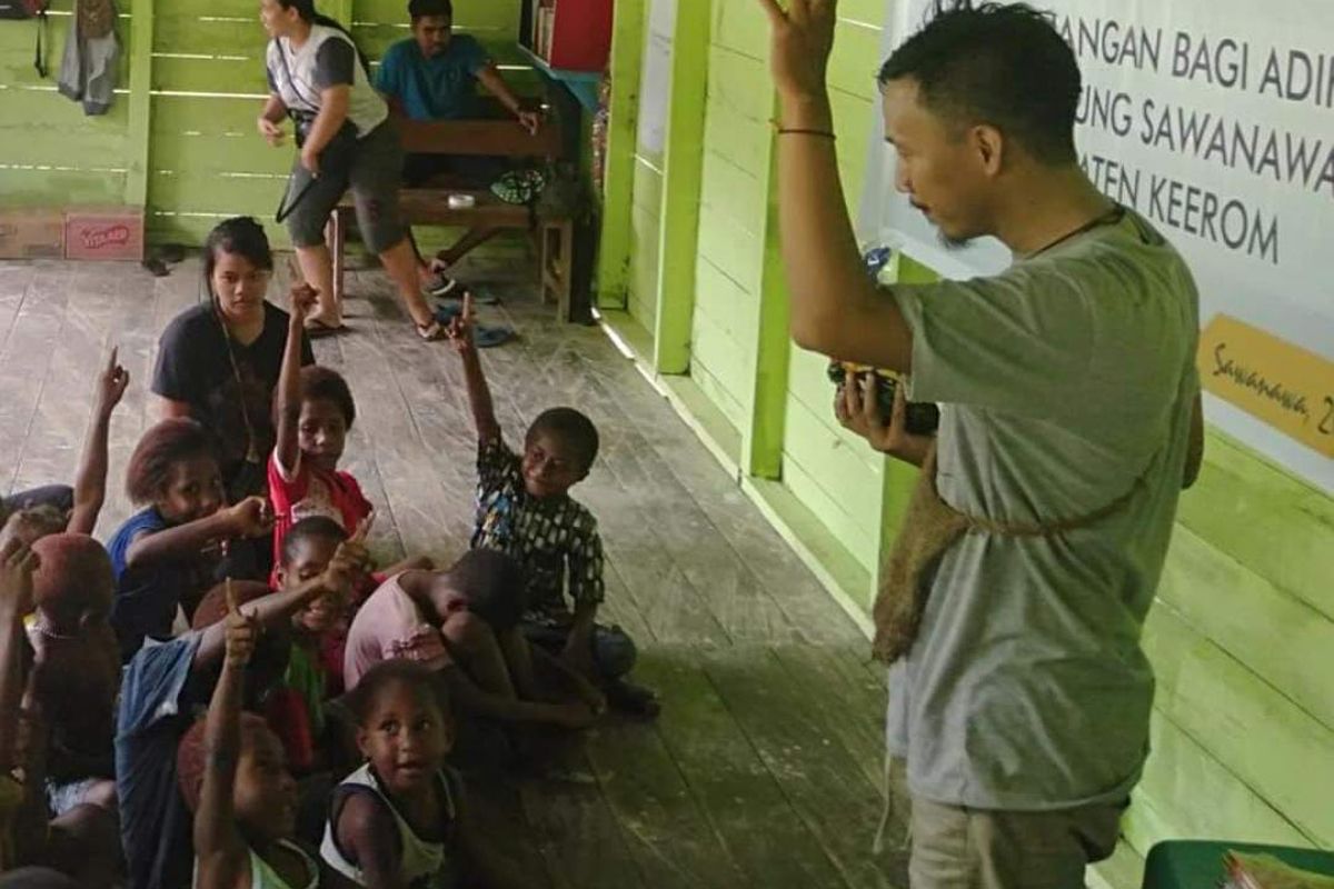 Pendiri Komunitas LIFE, Kuniawan Patma, saat mengajari anak-anak tentang literasi baca tulis di Kampung Sawanawa, Distrik Arso, Kabupaten Keerom, Provinsi Papua tahun 2019.