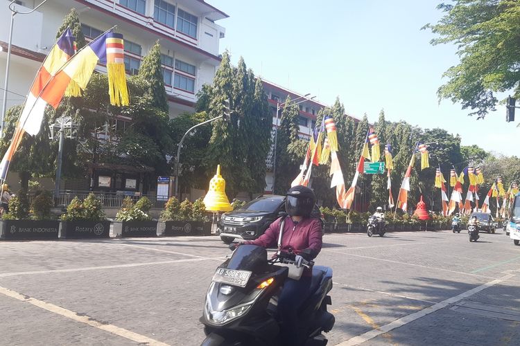 Pengendara melintas di Jalan Jenderal Sudirman Solo yang dihiasi penjor bendera Buddhis dan replika stupa candi, Senin (29/5/2023). Pemasangan ornamen tersebut dalam rangka menyambut Hari Raya Waisak 2567 TB/2023.