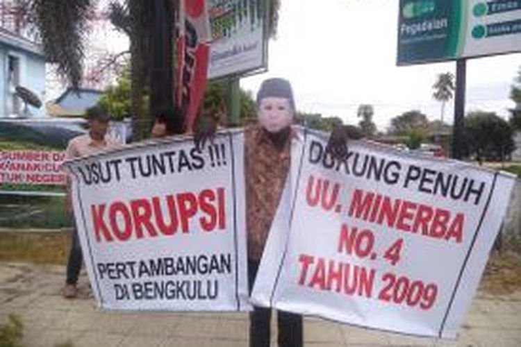 Salah seorang peserta aksi dengan menggunakan foto Wajah Gubernur Bengkulu, Junaidi Hamsyah, membawa tulisan dukungan implementasi UU Minerba dan bongkar kasus korupsi pertambangan di daerah itu