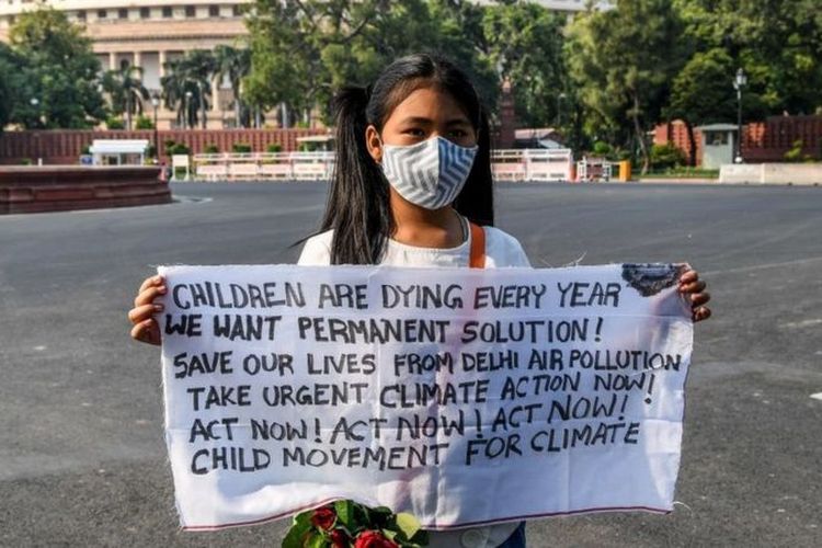 Seorang gadis memprotes polusi udara di Kota Delhi.