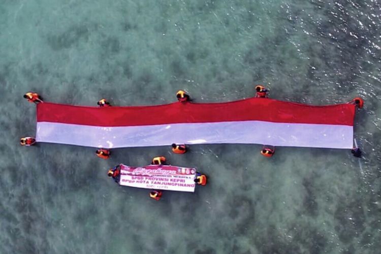 30 personil gabungan dari BPBD Kepri dan Kota Tanjungpinang melakukan pengibaran bendera merah putih raksasa di tengah laut perairan Kepri