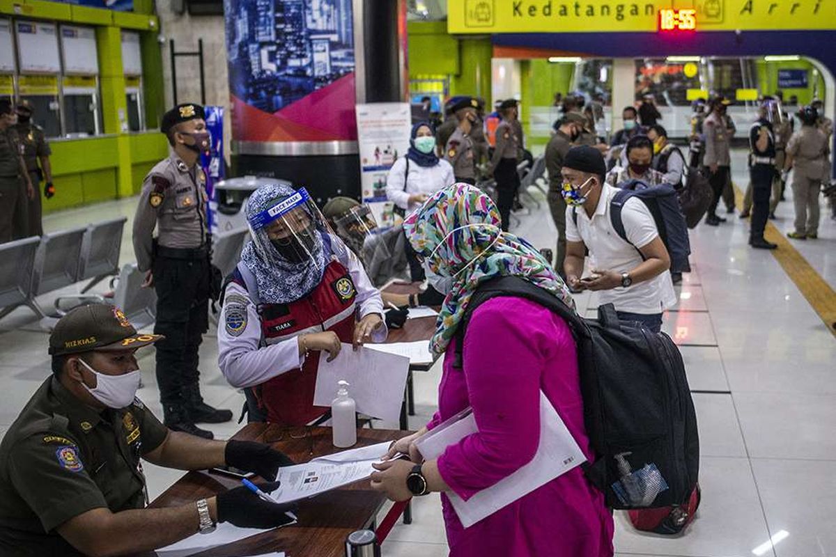 Petugas melakukan pemeriksaan dokumen penumpang Kereta Api Luar Biasa (KLB) Gambir-Surabaya Pasarturi saat tiba di Stasiun Gambir, Jakarta, Selasa (26/5/2020). Gubernur DKI Jakarta Anies Baswedan telah mengeluarkan Pergub DKI Nomor 47 Tahun 2020 tentang Surat Izin Keluar-Masuk (SIKM) sebagai syarat mutlak yang harus dimiliki oleh warga untuk keluar atau masuk ke wilayah Jakarta yang bertujuan untuk menekan angka kasus Covid-19.