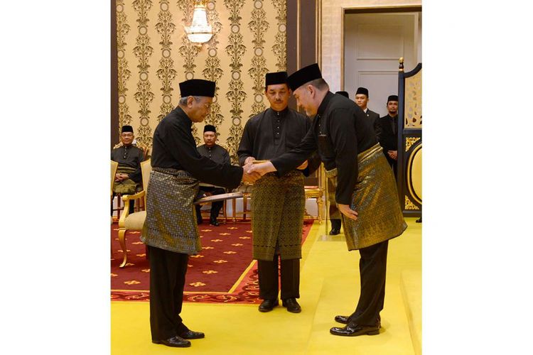 Perdana menteri terpilih Malaysia Mahathir Mohamad (kiri) berjabat tangan dengan Yang di-Pertuan Agong, Sultan Muhammad V dari Kelantan, saat acara pelantikan Mahathir sebagai Perdana Menteri Malaysia di Istana Negara, Kuala Lumpur, Kamis (10/5/2018) malam, waktu setempat. Mahathir Mohamad dari koalisi Pakatan Harapan resmi menjadi perdana menteri ketujuh Malaysia usai mengalahkan perdana menteri petahana Najib Razak dari koalisi Barisan Nasional.