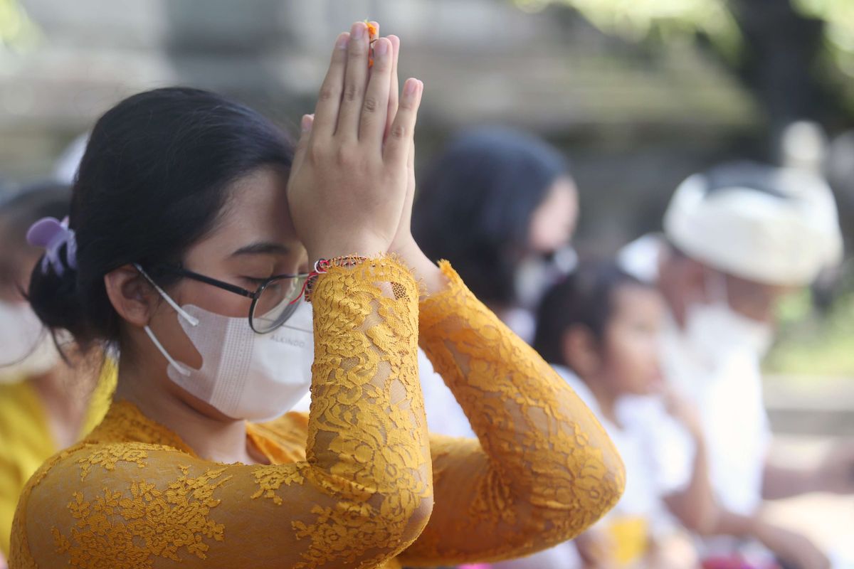 Umat Hindu melakukan persembahyangan yang menjadi bagian dari Upacara Tawur Agung dengan mengenakan gelang Tridatu.