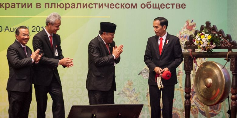 Presiden Joko Widodo (kanan) didampingi Ketua Mahkamah Konstitusi Arief Hidayat (kedua kanan), Gubernur Jawa Tengah Ganjar Pranowo (kedua kiri), dan Rektor UNS Ravik Karsidi (kiri) memukul gong saat pembukaan Simposium Internasional Asosiasi Mahkamah Konstitusi dan Institusi Sejenis se-Asia atau The Association of Asian Constitutional Court and Equivalent Institusions (AACC) di UNS, Solo, Jawa Tengah, Rabu (9/8/2017). Pertemuan yang dihadiri Ketua Mahkamah Konstitusi (MK) dan Institusi sejenis se-Asia dari 13 negara anggota AACC dan tujuh negara sahabat Eropa-Afrika tersebut mengangkat tema Mahkamah Konstitusi sebagai Penjaga Ideologi dan Demokrasi dalam Masyarakat Majemuk. ANTARA FOTO/Mohammad Ayudha/kye/17. 