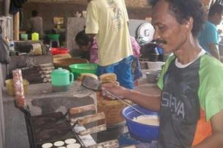 Seorang pekerja tengah memanggang kue gapit di rumah produksi milik Hj Kulsum, Dusun Babadan Barat RT 04/04, Desa Battembat, Kecamatan Tengah Tani, Kabupaten Cirebon. Kue gapit dengan merek dagang 24 itu dibuat aneka rasa. 