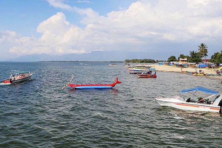 Wisatawan menikmati keindahan Danau Toba di Pantai Pasir Putih Lumban Bulbul, Kecamatan Balige, Kabupaten Toba Samosir, Sumatera Utara, Jumat (9/6/2017). 