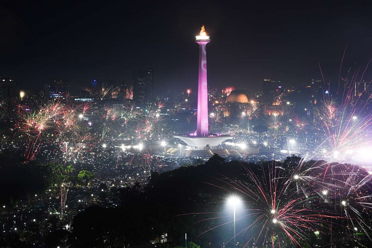 Warga menyalakan kembang api saat malam pergantian tahun baru di kawasan Monas, Jakarta, Selasa (1/1/2019).