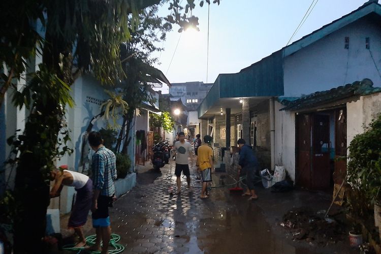 Warga Klitren Lor saat membersihkan sekitar rumahnya usai banjir.