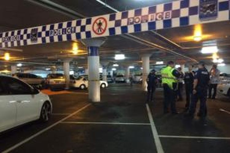 Garis polisi dipasang di lahan parkir di sebuah pusat perbelanjaan di Brisbane, Australia lokasi seorang nenek renta tewas setelah tak sengaja ditabrak suaminya sendiri yang sedang memarkir mobil mereka.