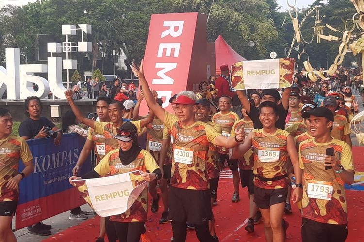 Gubernur Jawa Tengah Ganjar Pranowo (tengah) melintasi garis finis bersama pelari Indonesia, Agus Prayogo (kiri), dalam rangkaian agenda Friendship Run Jakart di Lapangan Banteng, Minggu (21/5/2023) pagi WIB.