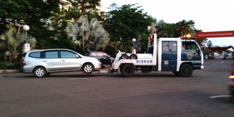 Sebuah mobil diderek oleh petugas Dishub DKI di dalam Ancol. Banyak kendaraan yang parkir sembarangan di bahu jalan pada perayaan tahun baru ini. Kamis (31/12/2015)