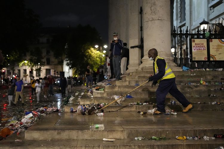 Seorang pekerja membersihkan sampah-sampah di tangga London tengah, Minggu (11/7/2021), seusai laga final Euro 2020 yang dimenangi Italia via adu penalti melawan Inggris di Stadion Wembley.