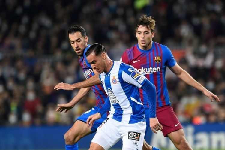 Penyerang Espanyol Raul de Tomas berduel dengan pemain Barcelona dalam laga lanjutan Liga Spanyol di Stadion Camp Nou pada 20 November 2021.