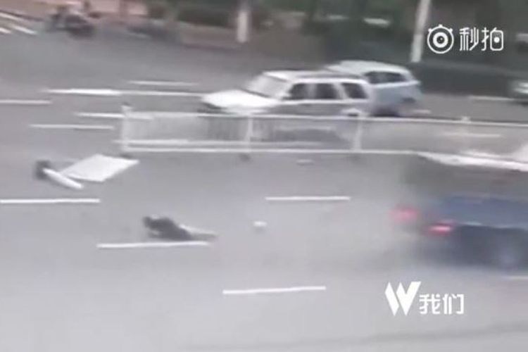 Dalam foto yang diambil dari rekaman CCTV ini terlihat sosok perempuan yang lolos dari maut sementara sepeda motornya terseret sebuah truk yang melaju kencang di sebuah ruas jalan di kota Guangxi, China.