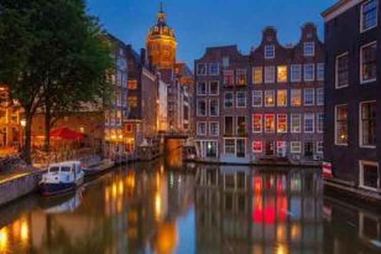 Rumah-rumah di pinggir kalan di kota Amsterdam, Belanda saat senja.
