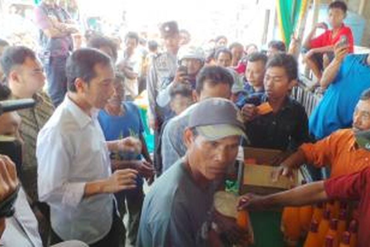 Gubernur DKI Jakarta Joko Widodo membagikan sembako bagi nelayan di Muara Angke, Jakarta Utara, Minggu (4/8/2013).