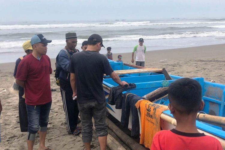 Sejumlah nelayan memeriksa kondisi perahu nelayan yang terbalik diterjang ombak Pantai Cikakap, Agrabinta, Cianjur. Dalam keadian itu seorang nelayan asal Indramayu dinyatakan hilang.