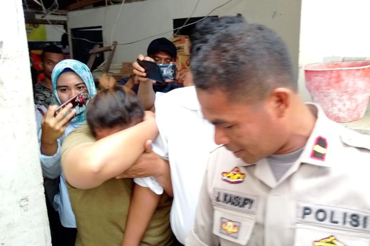 Sambil menutupi wajahnya, SH alias Ocah (25) digiring polisi ke sel tahanan Polres Pulau Ambon seusai menjalani pemeriksaan oleh penyidik unit PPA Satreskrim Polres Pulau Ambon, Rabu (10/4/2019)